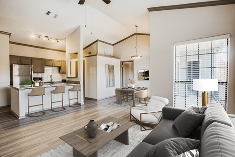 a living room with a couch and a table in front of a kitchen